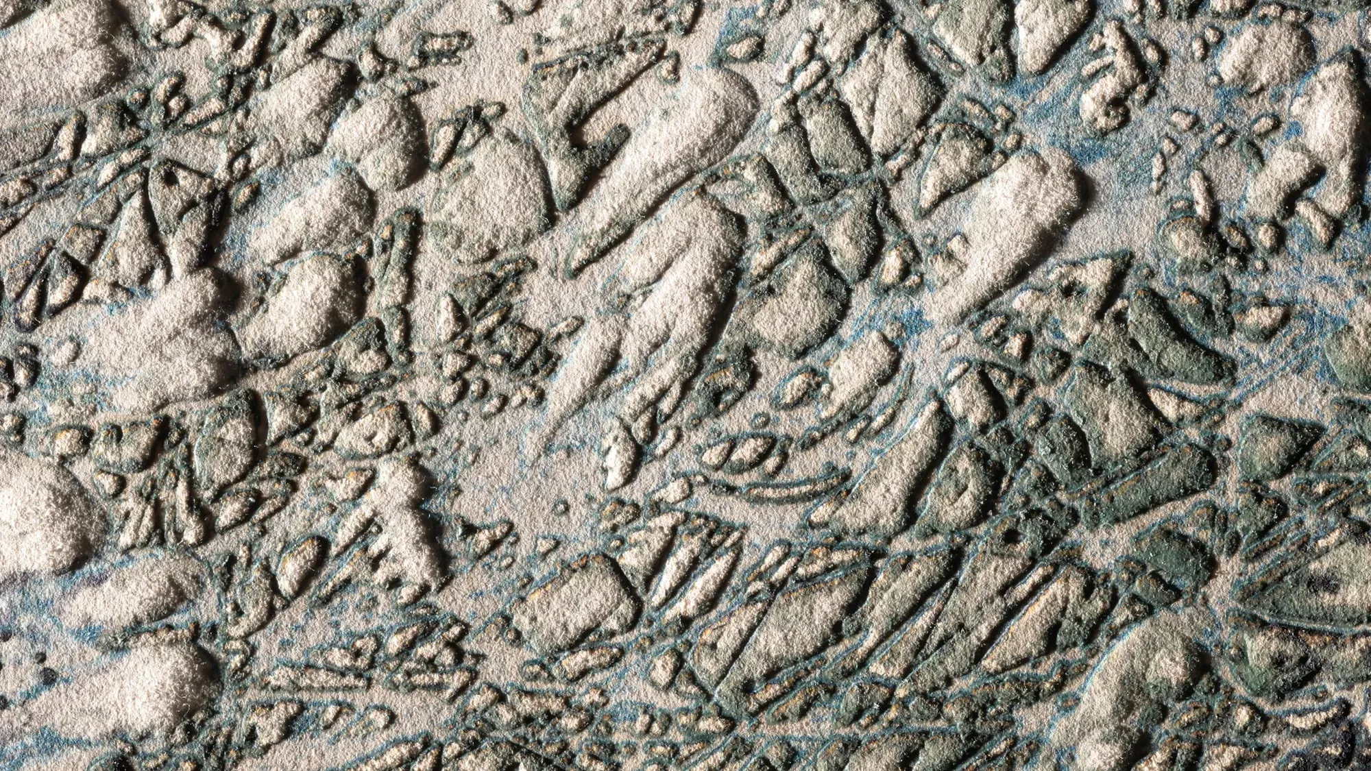 A close view of a deeply textured intaglio surface, its raised pale forms and incised lines catching blue-green ink.