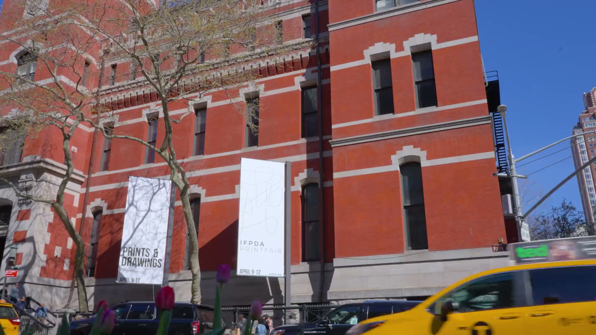 The Park Avenue Armory on a bright morning during the IFPDA Print Fair, with taxis passing on Park Avenue.
